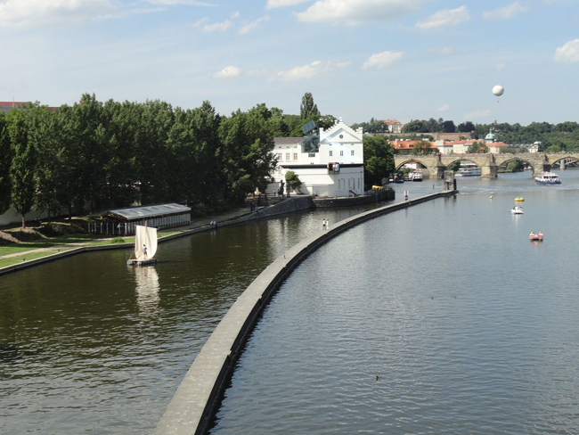 The “Ahoy Project.” Raft sailing down the Vltava River (far left) with the Charles Bridge, Prague, in the background, 2012. Image courtesy of ArtMill.