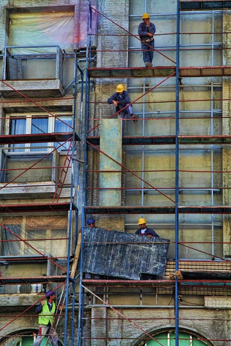 Le workers. (title of the photo). Workers rest while reconstructing the facade of “Pelister Hotel” building at the city square of Skopje. Image Courtesy of Vladimir Krle.