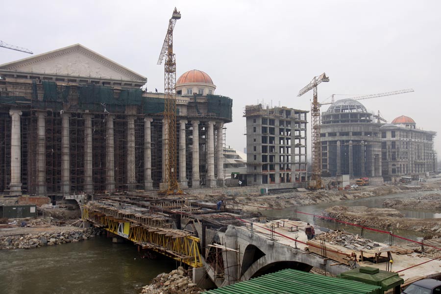 Building of the footbridge “Eye” on the river Vardar (front); In the back, from left to right: 1. The constitutional court, The National archives, The Archeological Museum (all three in the first building); 2. The electronic communications agency (the second building), 3. The Public Prosecutor’s Office and the Finance Police Office (the third building), 4. Colonnade building “Independent Macedonia” (the fourth building). Photo taken: 25 December 2011. Image Courtesy of Petar Kajevski