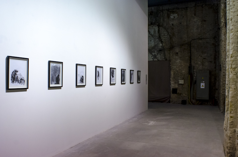 On the second floor, with its lower ceilings and more frequent dividing walls, visitors could experience more intimately individual videos and smaller drawings like Olga Chernysheva's series <em>A figure protected by…</em>, 2011-12, charcoal on paper. Many of the works were humble and candid, inviting the viewer to see the world for a moment through the artist's eyes. Image courtesy of the author. 