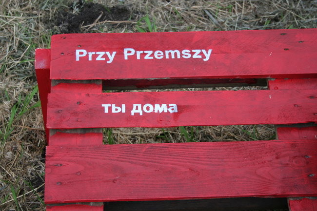 Matej Vakula, “Manuals for Public Space Bench,” detail, 2013, Bedzin, Poland. Each bench was stenciled with the sentence “At the river Przemsza, you are at home.” The first phrase of the sentence is in Polish, the second phrase is in the languages of the area -- Polish, Russian and Hebrew. Image courtesy of the artist.