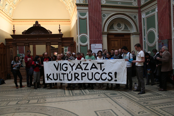 Protestors at the M?csarnok Kunsthalle with sign “Watch Out Cultural Putsch.” Image courtesy of Edit András.