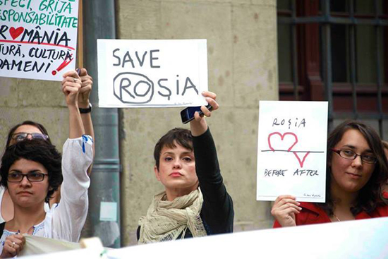 Scene from protest against cyanide mining of Rosia Montana, Romania. Protesters are displaying signs with drawings made by Dan Perjovschi, 2013. Image courtesy of the artist.