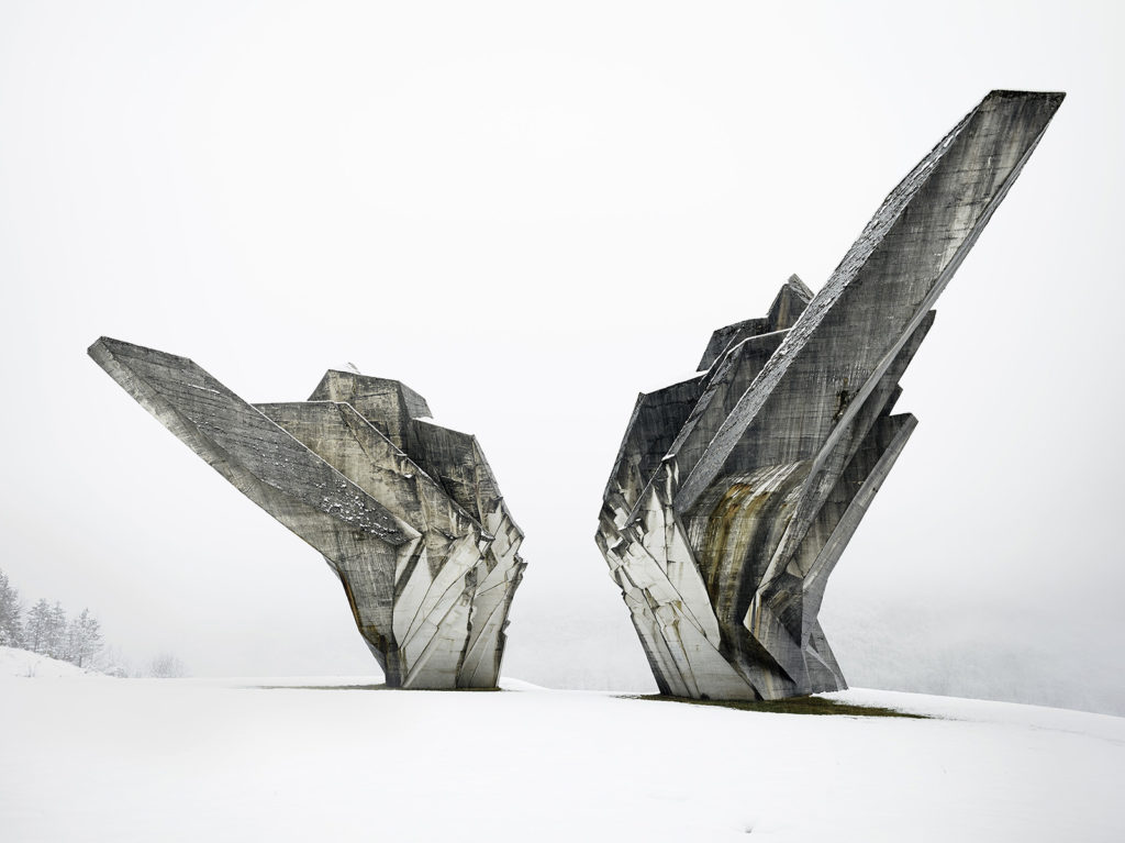 Two concrete structures in a snowy landscape.
