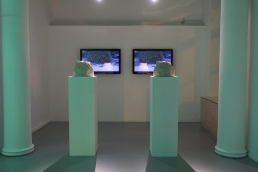 Two items on pedestals in front of TV screens
