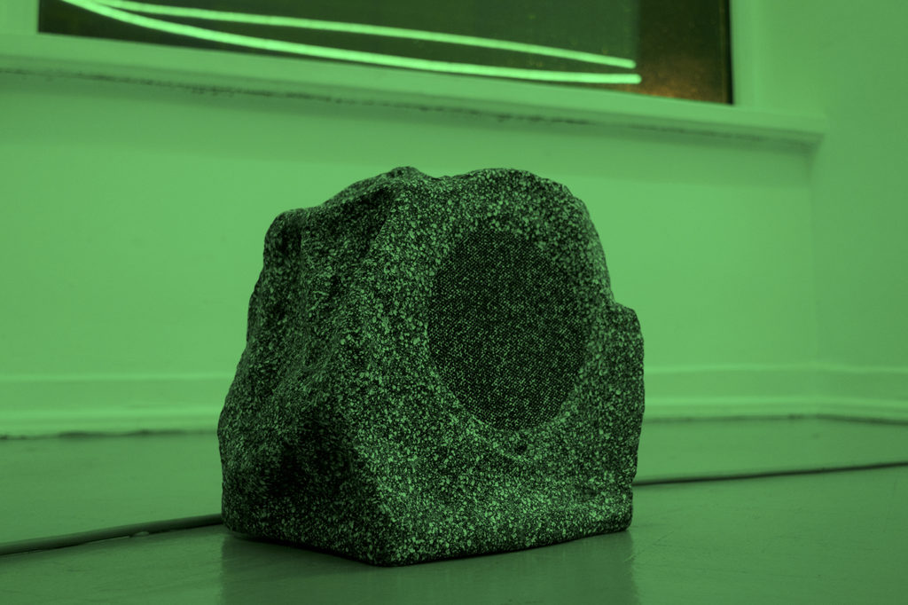 Rock with a round indentation in a green room.