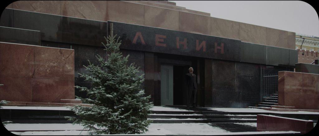 The Lenin mausoleum, with snow on the steps and the figure of Lenin standing at the doorway, looking up