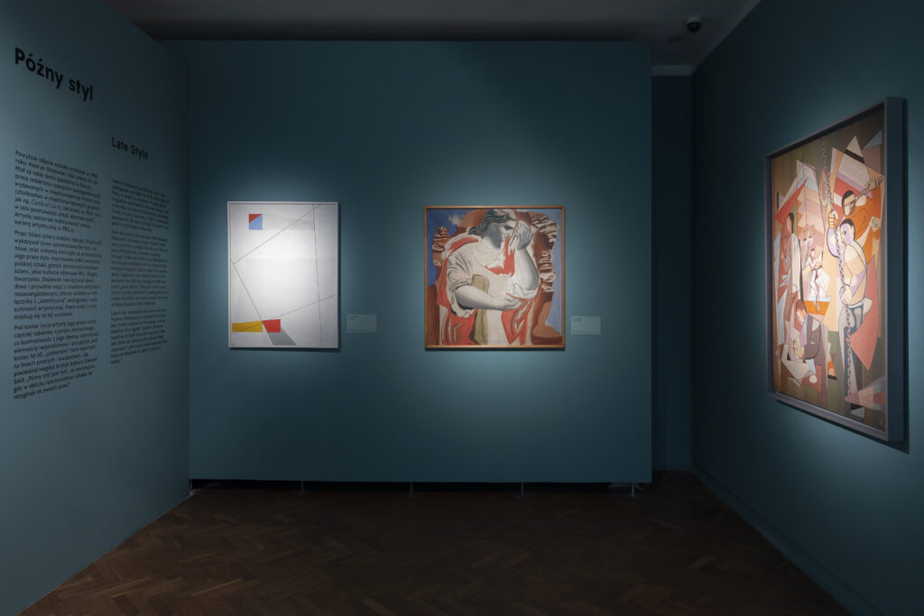 A room within the Henryk Stażewski exhibition displaying three paintings.