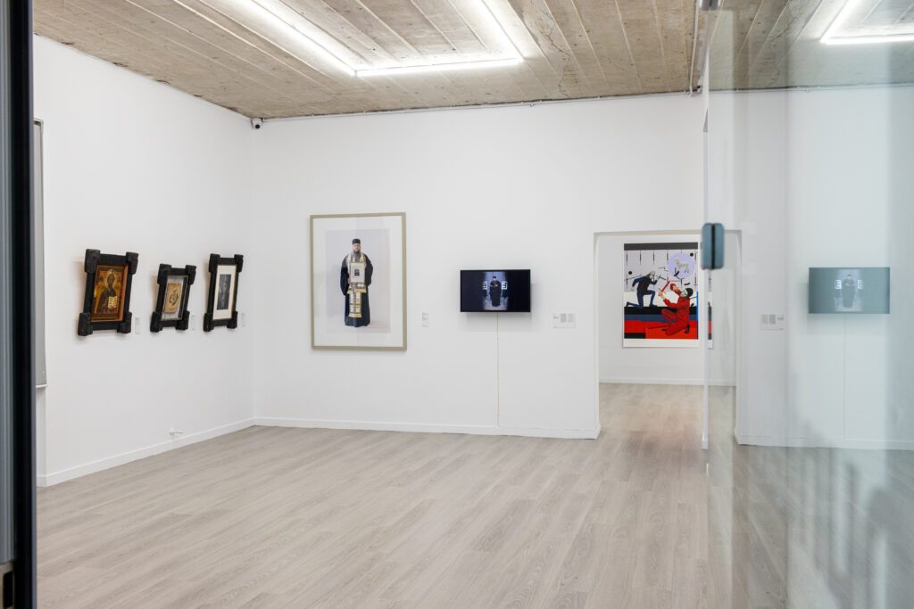 Exhibition interior with paintings, photographs and video pieces.